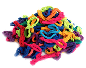 A collection of brightly colored Harrisville Potholder Loops, from the Traditional size Lotta Loops Pack by Friendly Loom, resembling cloth hair ties, is displayed against a white background. The loops come in a variety of colors including red, blue, purple, pink, green, orange, and yellow and are made of textured fabric.