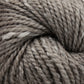 Close-up of a skein of Acadia by The Fiber Company from The Fibre Co. (UK) Ltd, showcasing its twisted fibers and soft texture. The yarn features a blend of light and dark grey tones with a subtle tweed effect, creating a heathered appearance.