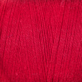 Close-up image of a ball of Maurice Brassard 8/2 Cottolin Organic Yarn | Mini-Cone in red with tightly wound fibers. The texture reveals the fine, interwoven strands, capturing the intricate details of the yarn's surface—a perfect complement to any Cottolin Tea Towel Kit.