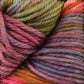 Close-up image of multi-colored yarn intertwined together. The Malabrigo Rios yarn from Malabrigo Yarn features kettle-dyed colors in shades of pink, green, purple, blue, and orange, creating a vibrant and textured pattern.