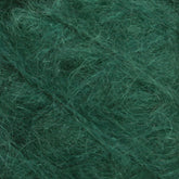 A close-up view of Caledonian Dye Works' Victorian Brushed Mohair Yarn | Mini Skein, showcasing its dark green, fuzzy tangles with numerous intertwined fibers. This luxurious yarn's soft, textured surface is emphasized in the image, highlighting the intricate patterns and depth that evoke classic Victorian aesthetics.