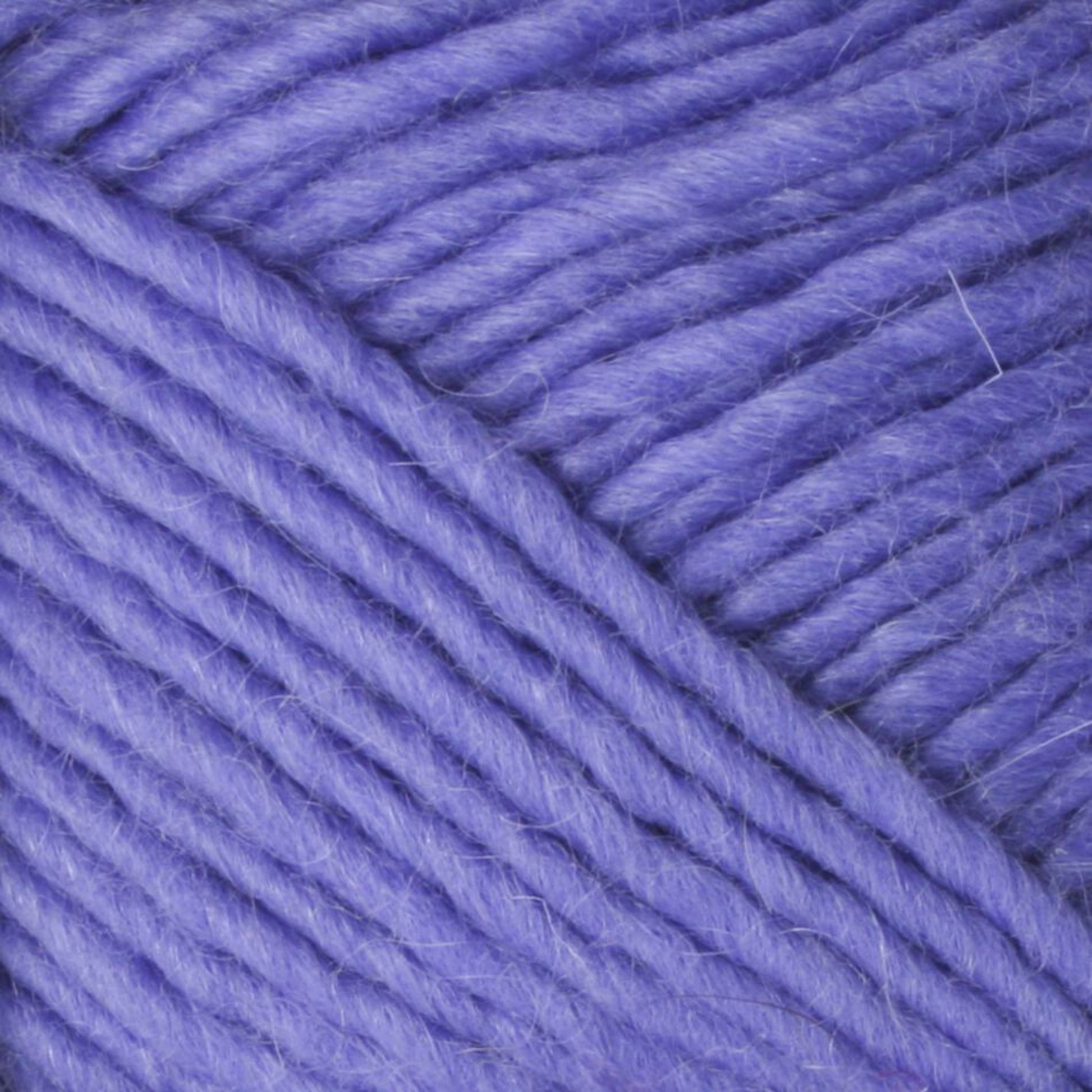 Close-up image of soft, thick, purple Lamb's Pride Worsted Yarn by Brown Sheep. The fibers are tightly wound together, showcasing their smooth and slightly fuzzy texture. The yarn appears plush and suitable for knitting or crocheting cozy projects like Navajo style weaving.