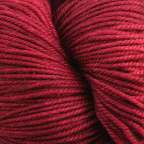 Close-up image of a skein of deep red Malabrigo Sock yarn by Malabrigo Yarn, showing the texture and tightly wound strands. The fibers appear soft and slightly glossy, highlighting the yarn's quality and rich color.