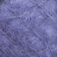 A close-up of the Victorian Brushed Mohair Yarn | Mini Skein by Caledonian Dye Works reveals a purple-textured surface with a fibrous appearance. The fibers, reminiscent of luxurious mohair, are tangled and intertwined, creating a fluffy, soft texture that resembles a dense, wool-like material. The color ranges from light to medium purple tones.