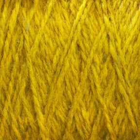 A close-up view of yellow wool yarn, displaying its soft, fibrous texture and interlocking strands. The yarn appears fuzzy and thick, with a vibrant, rich hue characteristic of Harrisville Designs' Harrisville Highland - Cones. Subtle traces of spinning oils are visible on the unscoured yarn.