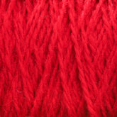 Close-up image of bright red Harrisville Shetland Yarn - Unwashed Cones by Harrisville Designs. The texture appears soft and slightly fuzzy, with intertwined strands creating a dense, woven pattern. The vibrant color and intricate details of the yarn are clearly visible, evoking thoughts of lightweight blankets.