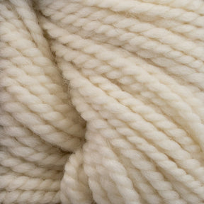 Close-up of thick, cream-colored Norumbega yarn by Caledonian Dye Works, showcasing the textured, twisted strands woven together. Made from 100% U.S. wool, the material appears soft and fluffy with a subtle sheen, creating a cozy and warm impression.