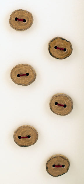 A photo showcasing Favour Valley Woodworking's "Six Buttons" reveals six vertically arranged wooden buttons, each featuring two holes and stitched with dark red thread. Set against a flat, neutral background, these locally crafted buttons exhibit a rustic charm with their natural wood grain patterns clearly visible.