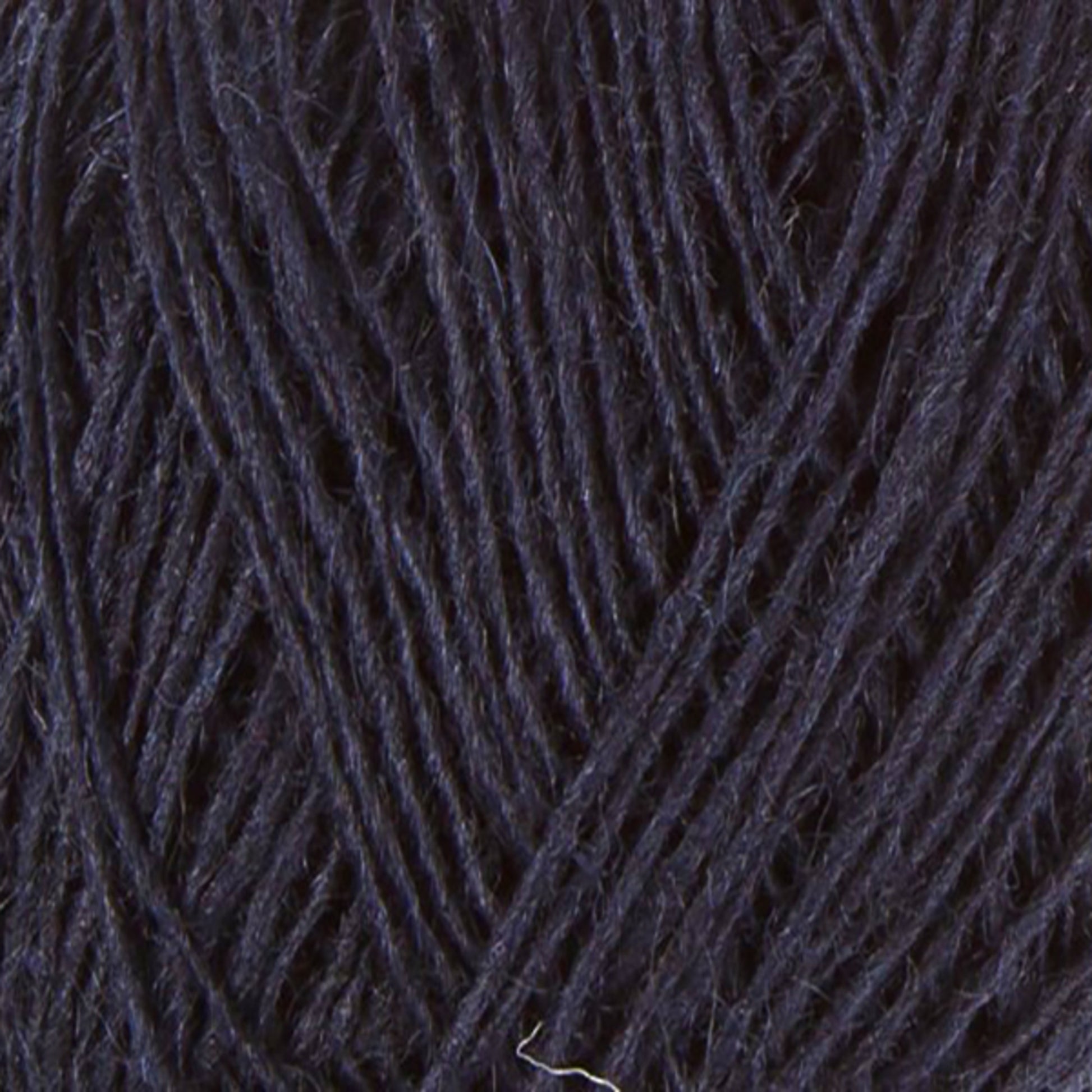 Close-up image of a ball of dark navy blue Einband Lopi yarn by Berroco, Inc., showing the texture and strands tightly wound together. The fibers appear slightly fuzzy, giving the yarn a soft and cozy appearance. Perfect for stranded colorwork projects that demand warmth and durability.