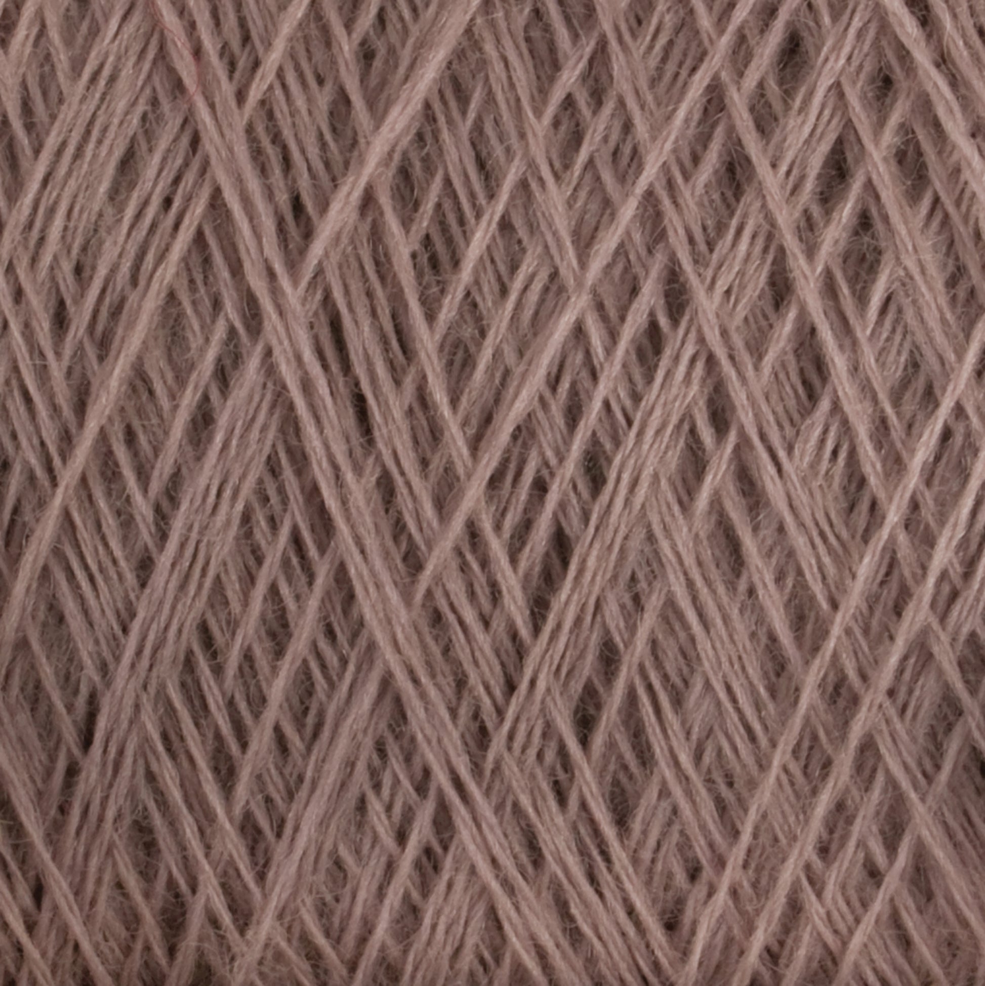 Close-up view of a ball of light brown JaggerSpun Maine Line 3/8 Yarn from Jagger Brothers, Inc. The yarn is tightly wound with visible overlapping strands, creating a textured and interwoven pattern. The fibers appear soft and slightly fuzzy, indicative of the natural or blended fiber composition typical of JaggerSpun yarns.