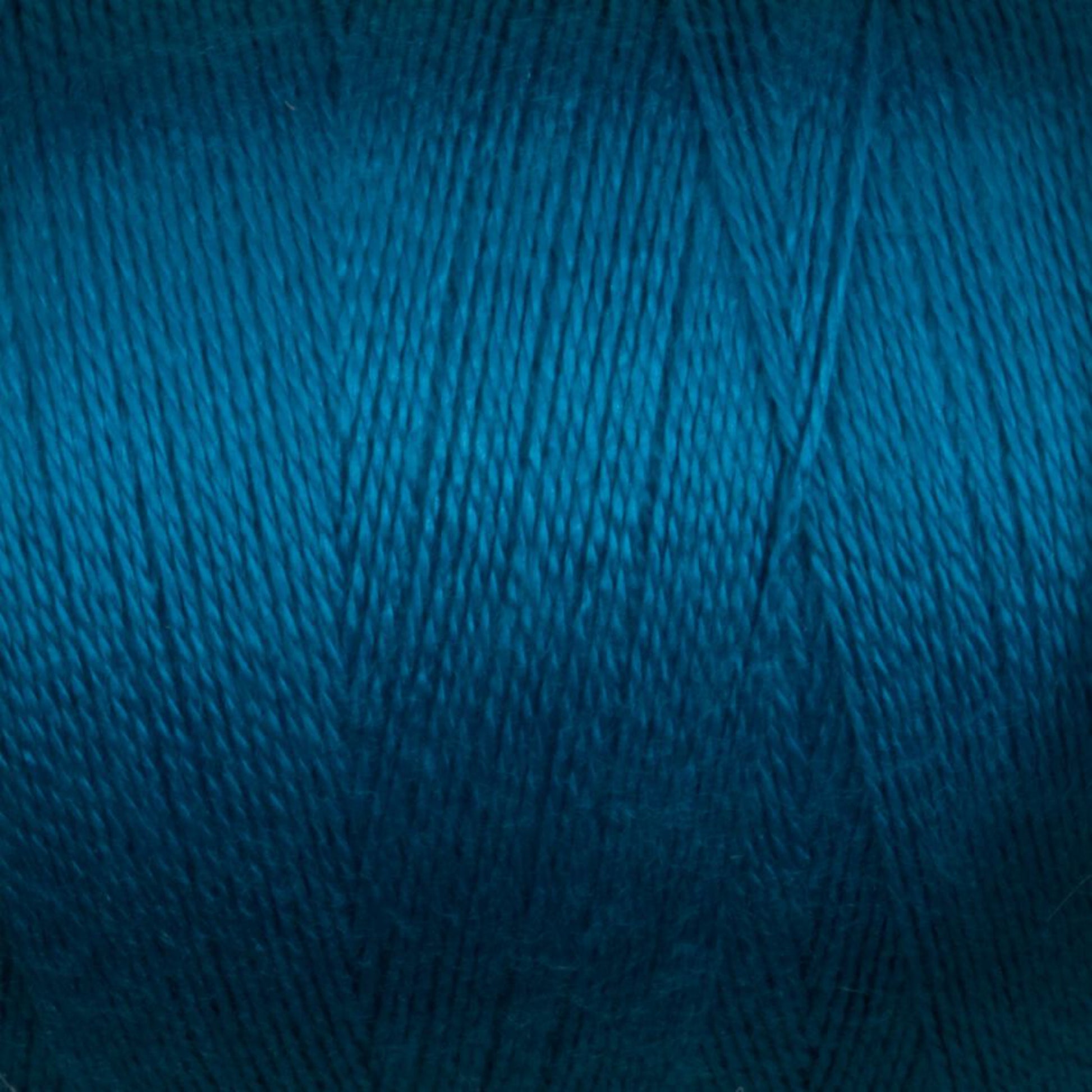 Close-up of a mini-cone of Maurice Brassard's 8/2 Bamboo Yarn in a rich, vibrant teal color, showcasing the fine texture and consistent winding of the fibers. The yarn appears smooth and slightly shiny, much like luxurious bamboo thread that appeals to environmentally friendly knitters.