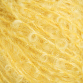 A close-up image of a ball of fluffy yellow yarn from Caledonian Dye Works' Victorian Bouclé Mohair Yarn. The soft and fuzzy texture with curly fibers evokes the cozy warmth typical of Victorian Bouclé.