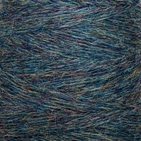 Close-up image of a skein of JaggerSpun Heather 3/8 yarn from Jagger Brothers, Inc. The yarn showcases a blend of blue, green, and purple hues, creating a textured, intertwined pattern. The fibers appear soft and slightly fuzzy, with various thicknesses visible in this worsted spun delight.