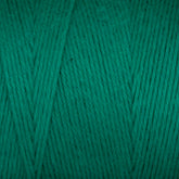 A close-up of a spool of Maurice Brassard's Cotton 8/8 Carpet Warp in green. The unmercerized cotton fibers are tightly wound together, showcasing the texture and consistency of the thread. The rich and vibrant shade of green fills the entire frame, making it perfect for knitting and crochet projects.