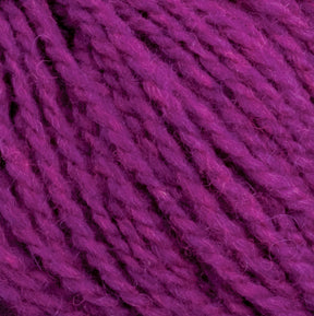 Close-up image of vibrant purple Harrisville Highland - Cones yarn by Harrisville Designs, featuring a twisted texture and soft, fuzzy appearance. The strands are tightly wound together, demonstrating the rich, even color and detailed texture of this unscoured yarn.