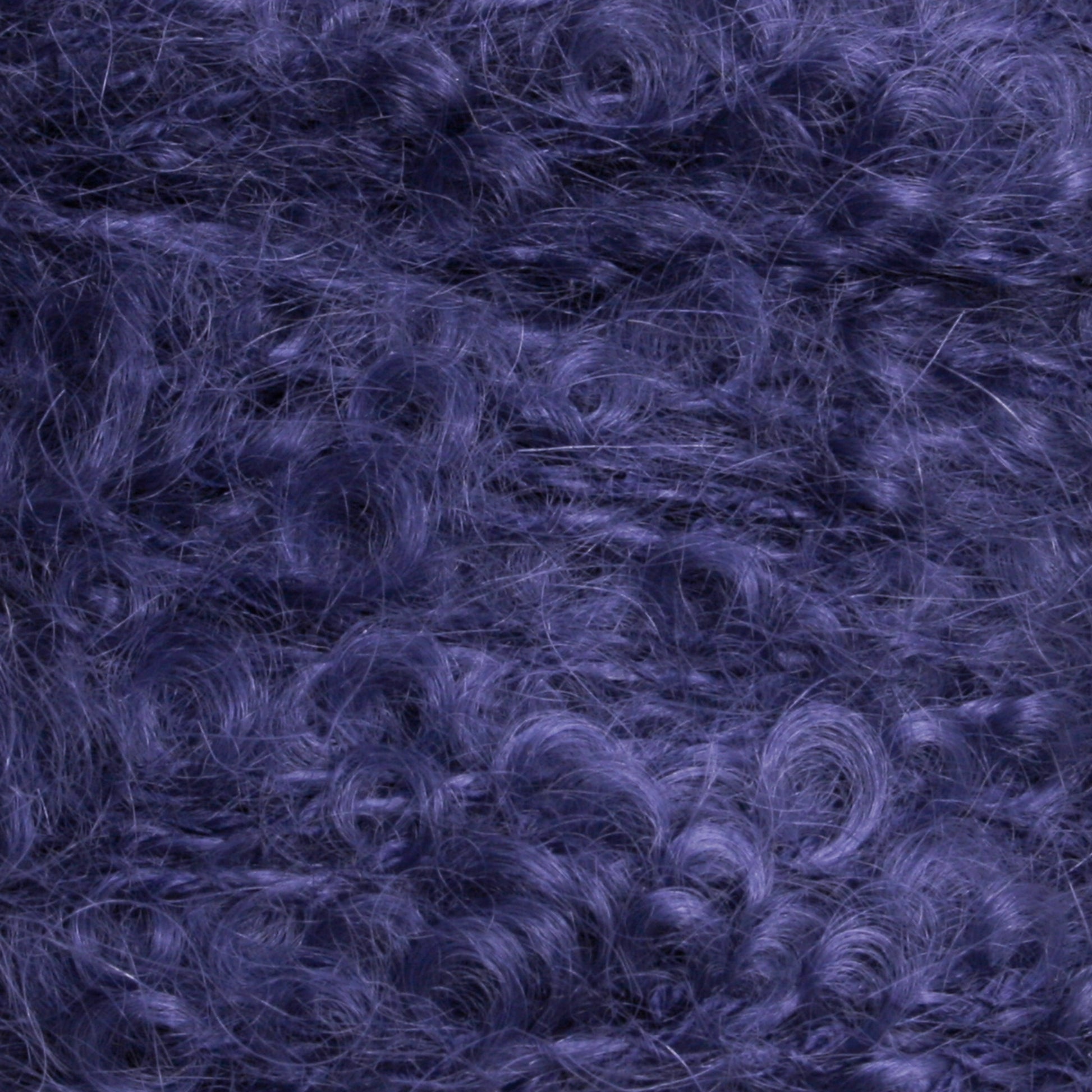 Close-up image of a textured, soft, and fluffy dark purple material from Caledonian Dye Works' Victorian Bouclé Mohair Yarn collection, showcasing fine fibers and curly patterns resembling Mohair Bouclé.