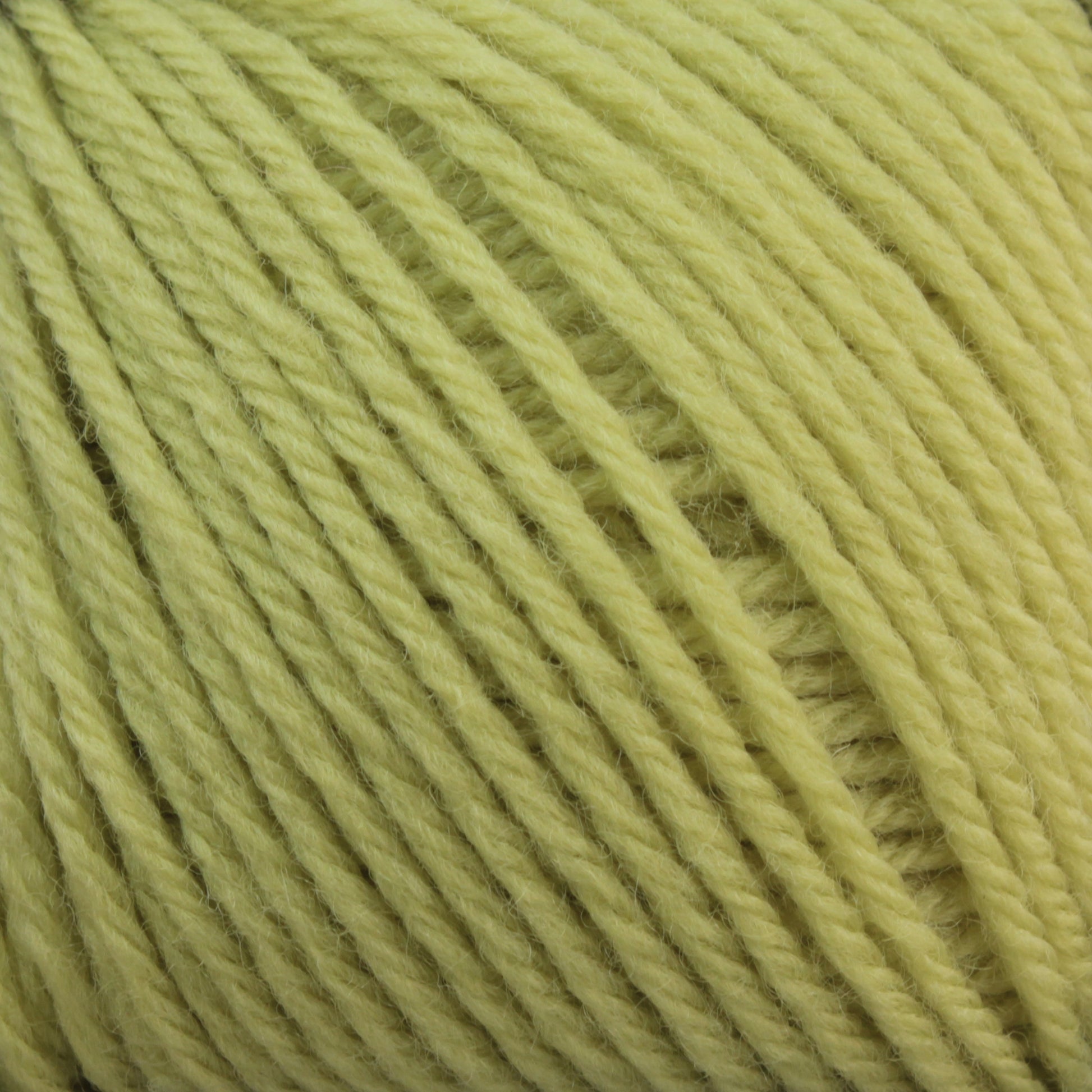 Close-up of a ball of light yellow Baby Blatt by Anny Blatt yarn, showcasing the soft texture and tightly wound strands. The fingering weight fibers from Essentially Felt Studio & Fine Yarn are consistent throughout, with individual fibers slightly visible, giving it a fluffy appearance. Plus, it’s machine washable for easy care.