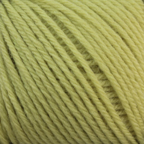 Close-up of a ball of light yellow Baby Blatt by Anny Blatt yarn, showcasing the soft texture and tightly wound strands. The fingering weight fibers from Essentially Felt Studio & Fine Yarn are consistent throughout, with individual fibers slightly visible, giving it a fluffy appearance. Plus, it’s machine washable for easy care.