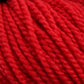 Close-up of a bundle of bright red Norumbega yarn by Caledonian Dye Works, showcasing its thick, twisted strands and soft, fibrous texture. The image highlights the vibrant color and detailed surface of the Aran weight yarn, made from 100% U.S. wool, indicating it may be suitable for knitting or crocheting projects.