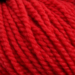 Close-up of a bundle of bright red Norumbega yarn by Caledonian Dye Works, showcasing its thick, twisted strands and soft, fibrous texture. The image highlights the vibrant color and detailed surface of the Aran weight yarn, made from 100% U.S. wool, indicating it may be suitable for knitting or crocheting projects.