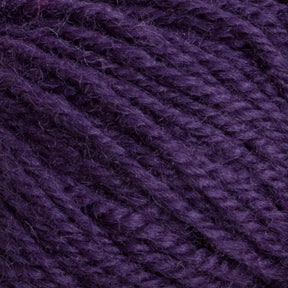 A close-up image of Halcyon Deco Rug Wool, by Caledonian Dye Works, showcasing its textured fibers and tightly twisted strands. The versatile yarn appears soft and plush, with a rich, deep purple color.