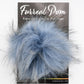 A package with a fluffy faux fur pom-pom attached, primarily light blue with some strands of white and black mixed in. The packaging reads "Furreal Pom by KFI" at the top, from the brand Knitting Fever / Euro Yarns.