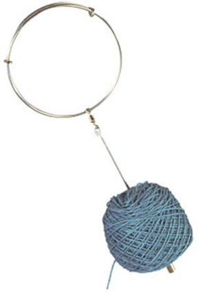 The Wrist Yarn Holder by Handy Hands features a metal ring attached to a rod, which is securely fixed to a tightly wound blue ball of yarn. This setup functions perfectly as a DIY wrist yarn holder, making it ideal for aiding in the unrolling or usage of the yarn.