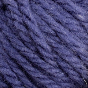 Close-up image of a textured purple skein from the Halcyon Yarn Classic Rug Wool collection by Caledonian Dye Works, showcasing its detailed fibers and strands. The hand-dyed yarn appears soft and thick, suitable for knitting or crocheting projects. The color is a rich, deep shade of purple, highlighting the intricate twists of the fibers.