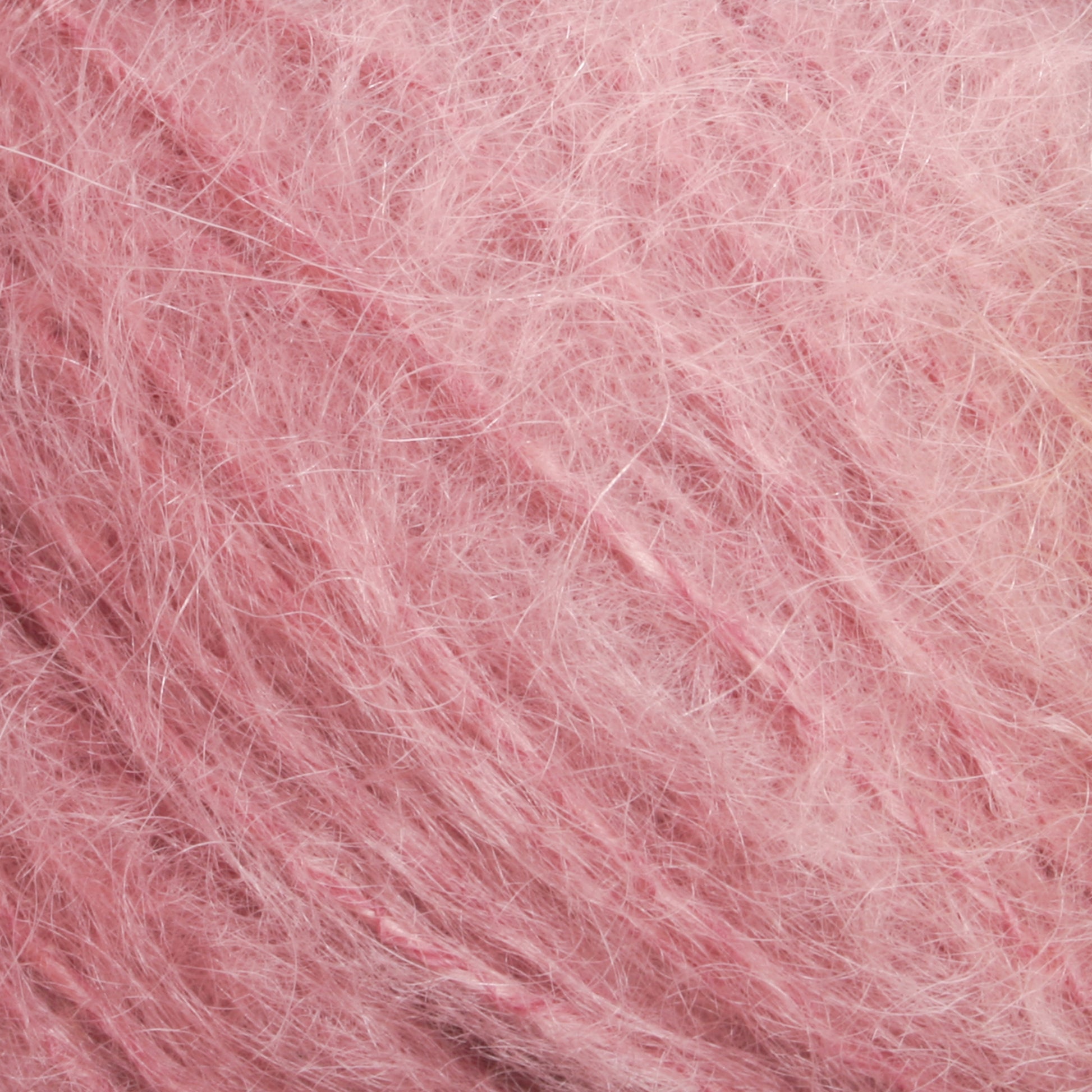 Close-up of fluffy, pink Victorian Brushed Mohair Yarn with a soft, fuzzy texture. The luxurious mohair fibers from Caledonian Dye Works are fine and wispy, creating a delicate and cozy appearance. The image captures the intricate details of Halcyon Yarn’s surface in this large skein.