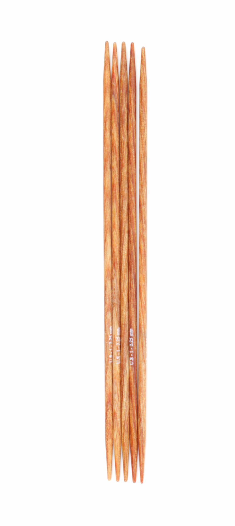 A set of five Dreamz Double Point Knitting Needles by Knitter's Pride, crafted from laminated birch and measuring 5 inches each, are arranged side by side, showcasing their smooth, polished surfaces and wood grain patterns. These tools from Accessories Unlimited are commonly used for knitting small circular projects such as socks or mittens.