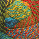 Close-up image of colorful twisted yarn balls. The Zauberball Crazy Sock Yarn by Skacel features a variety of bright colors, including shades of blue, green, yellow, red, and orange. The strands are tightly wound together with subtle color changes, creating a vibrant and textured pattern.