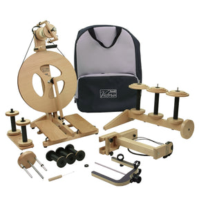 The Louët Victoria Double-Treadle Folding Spinning Wheel kit by Louët Inc. is showcased with a wooden spinning wheel, multiple spindles, bobbins featuring an adjustable bobbin brake, a lazy kate, and various accessories. The set includes a dark-colored carry bag with "Victoria" printed on it. The items are arranged neatly against a plain white background.