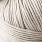 A close-up of a ball of Kingfisher Yarn & Fibre's Jo Sharp Soho Summer DK Cotton with tightly wound fibers, showing detailed texture. The yarn appears soft and smooth, perfect for summer knitting or crocheting projects. The background is blurred, drawing focus to the lightweight cotton yarn.