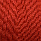 Close-up view of bright red 8/2 Bamboo Yarn from Maurice Brassard, tightly wound into a mini-cone. The texture of the yarn strands is clearly visible, showcasing the smooth and slightly glossy finish of the fibers—perfect for knitters seeking an environmentally friendly option with bamboo yarn's natural allure.