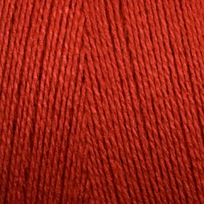 Close-up view of bright red 8/2 Bamboo Yarn from Maurice Brassard, tightly wound into a mini-cone. The texture of the yarn strands is clearly visible, showcasing the smooth and slightly glossy finish of the fibers—perfect for knitters seeking an environmentally friendly option with bamboo yarn's natural allure.