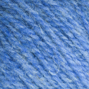 Close-up image of Bartlettyarns Maine Wool Yarn. The texture is detailed, revealing soft fibers interwoven to form a thick, slightly fuzzy thread. This worsted weight yarn from Bartlettyarns features varying shades of heathered colors, adding depth and dimension to the overall appearance.