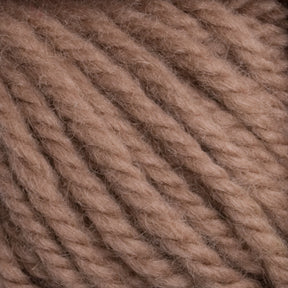 Close-up of Halcyon Yarn Classic Rug Wool from Caledonian Dye Works in a beige hue. The yarn strands are thick and tightly twisted, creating a textured appearance with a soft and slightly fuzzy surface. Weavers appreciate how the Rug Wool's intricate details and fibrous nature stand out in this image.