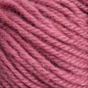 A close-up view of Caledonian Dye Works' Halcyon Deco Rug Wool, showcasing a tightly wound, soft, and textured pattern in pink. The strands are visible with a slightly fuzzy surface and a uniform twist. This versatile 100% wool yarn is perfect for projects like making Deco rugs or cozy garments.