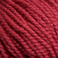 Close-up of a textured, thick red yarn. Norumbega by Caledonian Dye Works is an Aran weight yarn that is tightly twisted, creating a detailed, braided pattern. Made from 100% U.S. wool, the fibers appear soft and fluffy, highlighting the yarn’s cozy and warm characteristics suitable for knitting or crocheting.