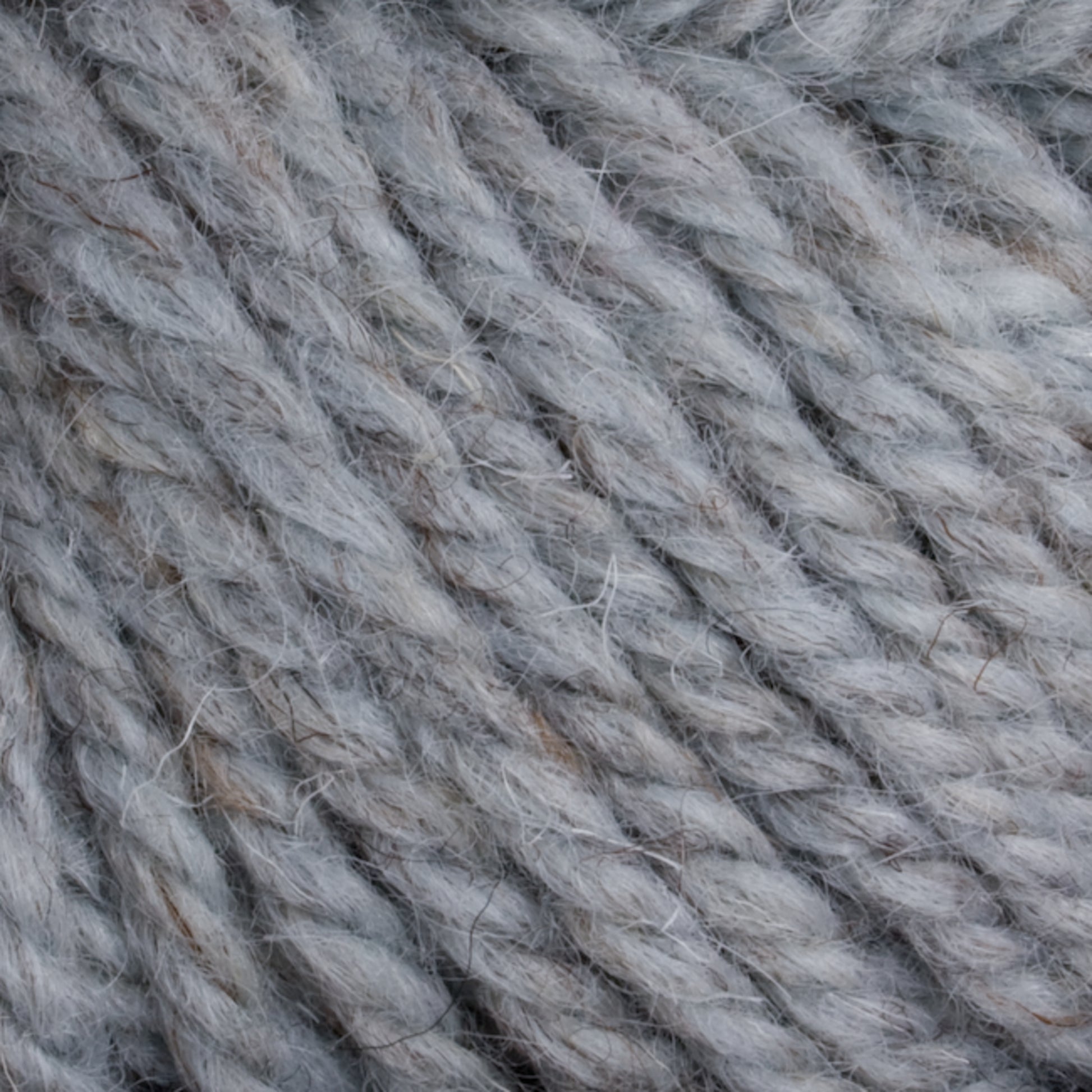 Close-up image of soft, thick Halcyon Yarn Classic Rug Wool from Caledonian Dye Works, featuring a rich gray color and slightly fuzzy texture. The tightly twisted strands exude a natural and cozy appearance, ideal for knitting or crocheting warm garments and accessories. Perfectly suited for rug weavers using Classic Rug Wool techniques.