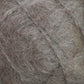 Close-up view of a ball of Caledonian Dye Works' Victorian Brushed Mohair Yarn - Large Skein. The fibers are loose and tangled, creating a textured and slightly chaotic appearance. Reminiscent of Victorian yarns, its grey-brown color varies with patches of darker and lighter shades, adding to the charm of this luxurious mohair blend.