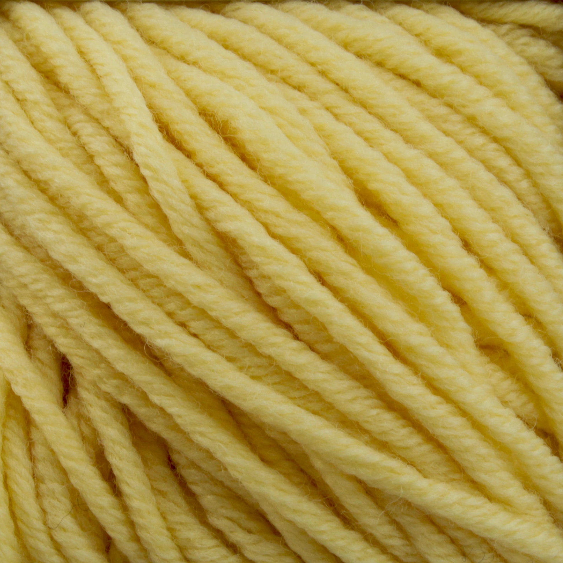 Close-up of thick, soft, yellow Plymouth Select Worsted Merino Superwash yarn by Plymouth Yarn Co. The individual strands are tightly twisted together, creating a textured surface with excellent stitch definition. The yarn appears to be of medium weight, suitable for knitting or crocheting projects.