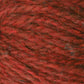 Close-up image of a ball of Peace Fleece Yarn by Harrisville Designs. The yarn appears to have a mixed texture with shades of red ranging from bright to dark, and it looks soft and woolly. This yarn is a wool and mohair blend, making it ideal for worsted weight knitting projects.