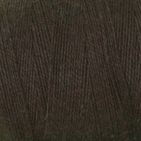 Close-up of the 8/2 Cottolin Organic Yarn from Maurice Brassard. The dark brown fiber has a soft and slightly fuzzy texture with tightly wound strands. Its color is consistent throughout, showcasing a rich, deep brown hue. This yarn could be perfect for your project on a four shaft loom or from the Cottolin Tea Towel Kit.