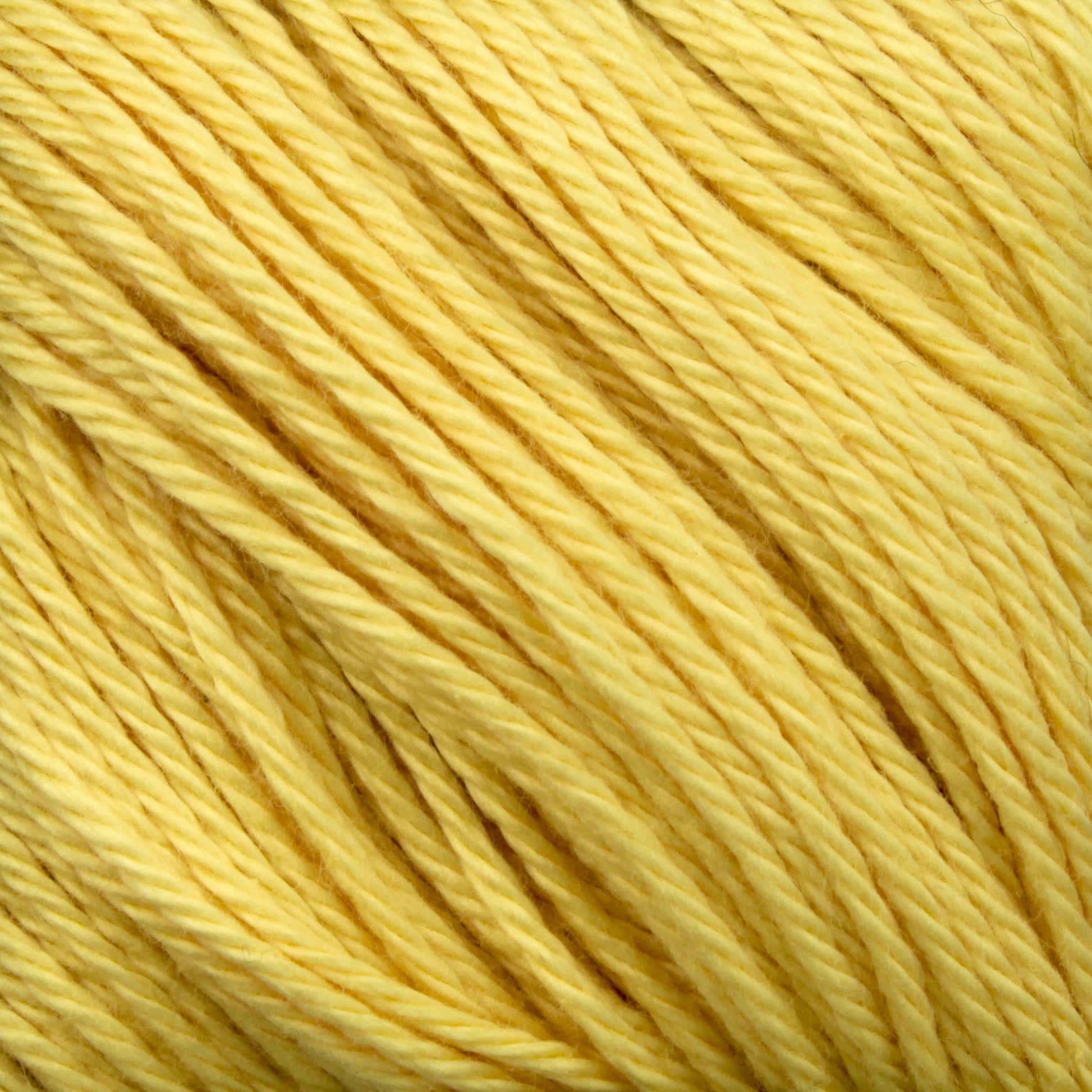 Close-up image of soft, twisted yellow yarn made from Cascade Ultra Pima Cotton Yarn. The texture of the Peruvian Pima Cotton fibers and the tightness of the twists are clearly visible, showcasing the yarn's smooth and even consistency. The bright, cheerful color conveys a warm and sunny feel.