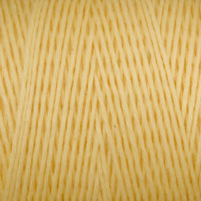 Close-up image of a skein of Maurice Brassard Cotton 8/8 Carpet Warp in a soft, light yellow color, tightly wound into an orderly coil. The yarn fibers are smooth and slightly shiny, with a consistent thickness throughout. This material appears ideal for knitting or crocheting projects.