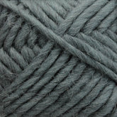 Close-up of a ball of thick, teal-colored Lamb's Pride Bulky Yarn by Brown Sheep. The fibers appear soft and slightly fuzzy, with the yarn tightly woven into a neat bundle—ideal for knitters and crocheters crafting cozy Icelandic sweaters or woven blankets.