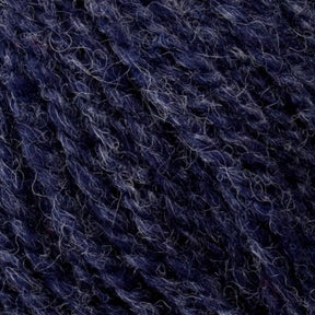 Close-up of Bartlettyarns' Bartletts Maine Wool - Sport in a rich deep blue, showcasing the intricate details of the premium fibers. The yarn exhibits a slightly fuzzy texture with lighter strands interwoven, creating a heathered effect. This image highlights the softness and complexity of the material.