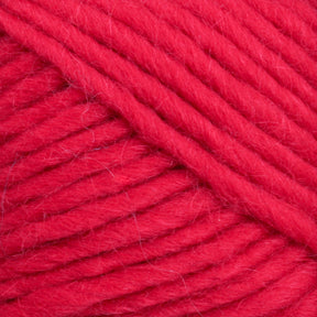 Close-up image of bright red Brown Sheep Lamb's Pride Worsted Yarn with a slightly fuzzy texture, neatly wound into a skein. The thick, tightly twisted strands showcase the fiber details, making it ideal for felting projects.