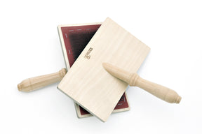 The Kromski Hand Carders by Kromski North America feature wooden handles and rectangular paddles. One paddle showcases fine metal teeth designed for carding wool. The light-colored handles of these paddles are crossed over each other.